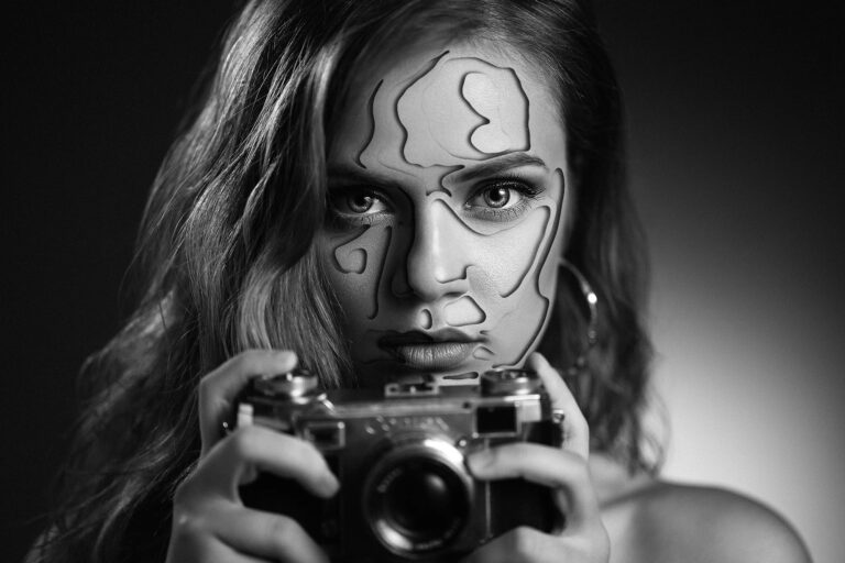 Retouche Photo faite par MP Designer Web - Portrait noir et blanc d'une femme avec un appareil photo à la main. Sur le visage de la femme, il y a des formes aléatoires qui font des effets de trous ou deuxième peau.